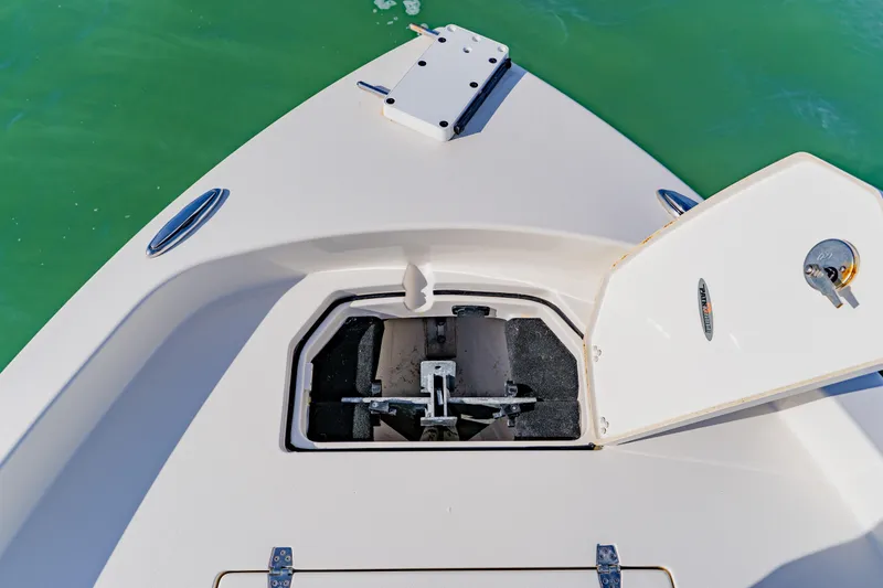 Slide: The Image of 2023 Pathfinder 2700 Open boat anchor compartment with open hatch, on calm green water. - 30