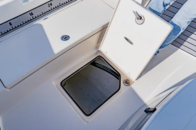 Slide: The Image of 2023 Pathfinder 2700 Open boat storage compartment with open hatch and measuring scale. - 31