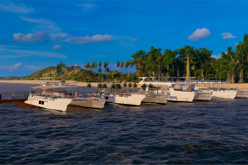 Slide: The Image of Custom PAXCAT 2027 catamarans docked by tropical island under clear blue sky. - 14