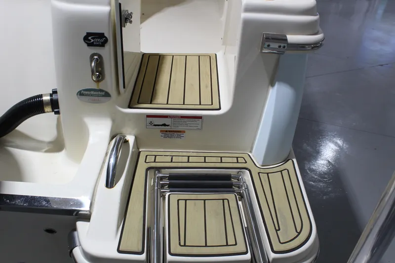 Slide: The Image of 2024 Scout 215 XSF boat deck with teak-style flooring and stainless steel ladder. - 32