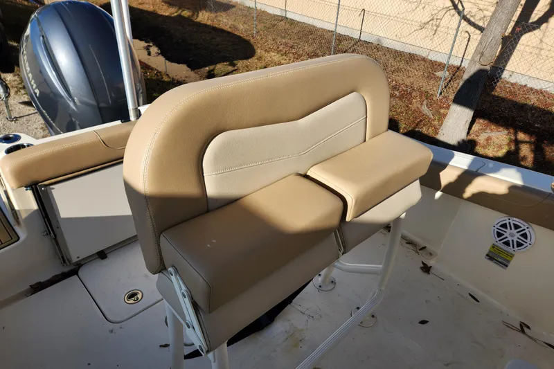 Slide: The Image of 2024 Scout 215 XSF boat with sleek design, parked outdoors under clear blue sky. - 7