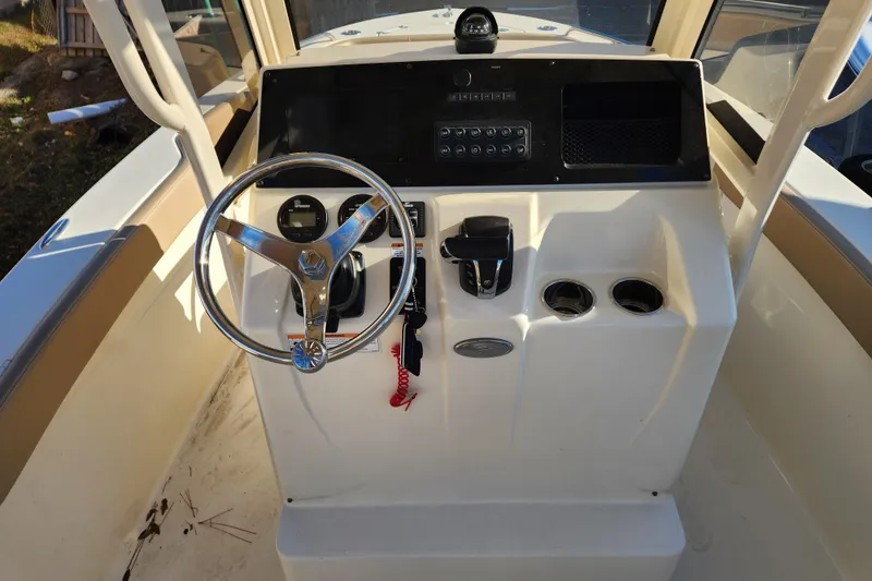 Slide: The Image of 2024 Scout 215 XSF boat dashboard with steering wheel and modern controls. - 9