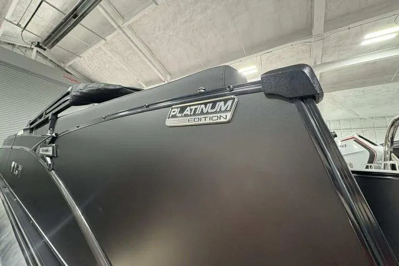 Slide: The Image of 2026 Avalon 2585 CAT QL Platinum Edition boat in showroom, sleek black exterior. - 11