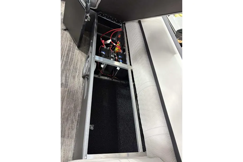 Slide: The Image of Open storage compartment in 2026 Avalon 2585 CAT QL boat, revealing wiring and battery setup. - 12