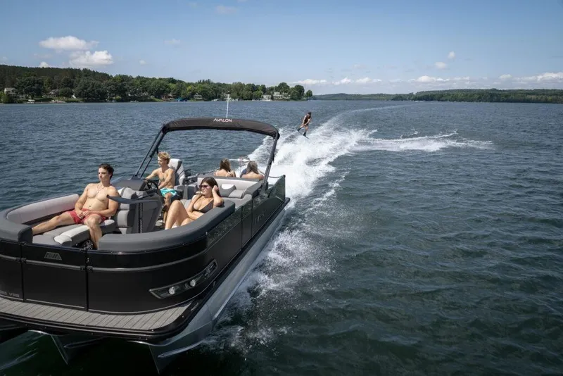 Slide: The Image of 2026 Avalon 2585 CAT QL pontoon boat with passengers and wakeboarder on a sunny lake. - 24