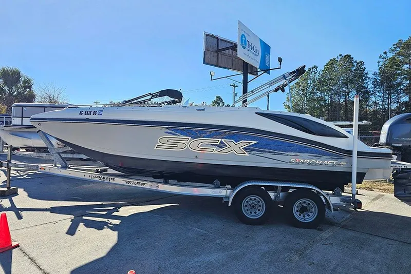 Slide: The Image of 2017 Starcraft Crossover 231 SCX OB boat on trailer, parked outdoors. - 1