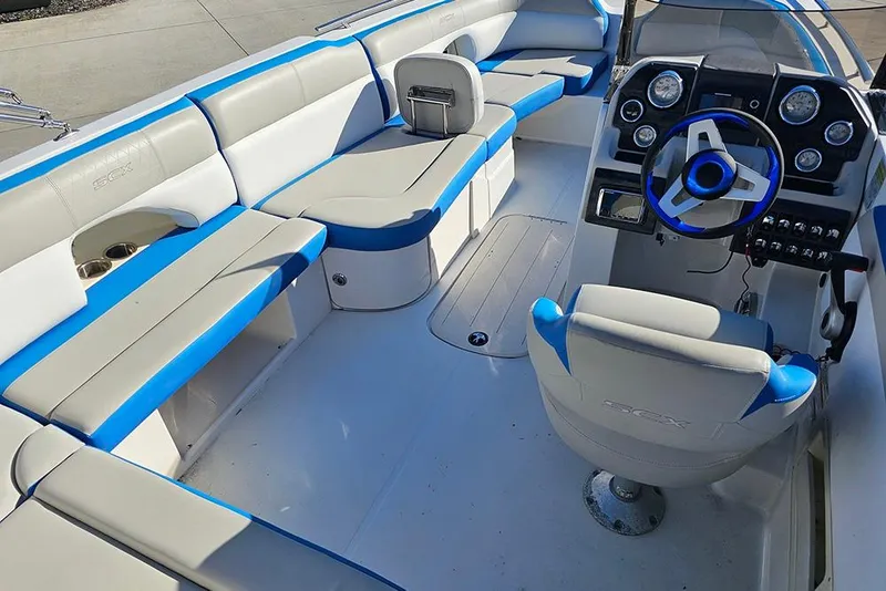 Slide: The Image of 2017 Starcraft Crossover 231 SCX OB boat interior with blue and gray seating and dashboard. - 11