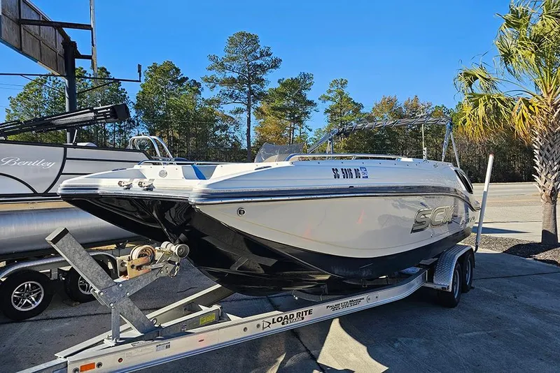 Slide: The Image of 2017 Starcraft Crossover 231 SCX OB boat on trailer, parked outdoors. - 2