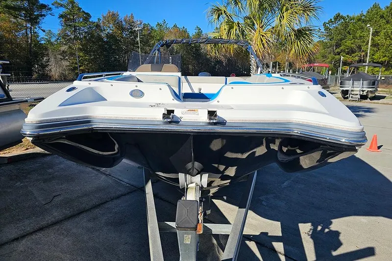 Slide: The Image of 2017 Starcraft Crossover 231 SCX OB boat on trailer, outdoor setting with trees. - 4