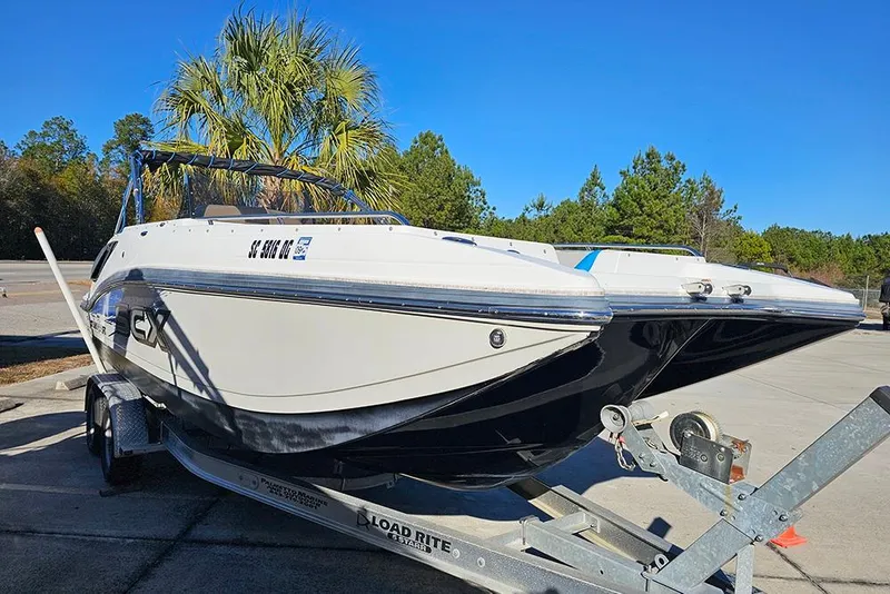 Slide: The Image of 2017 Starcraft Crossover 231 SCX OB boat on trailer, parked outdoors under clear blue sky. - 6