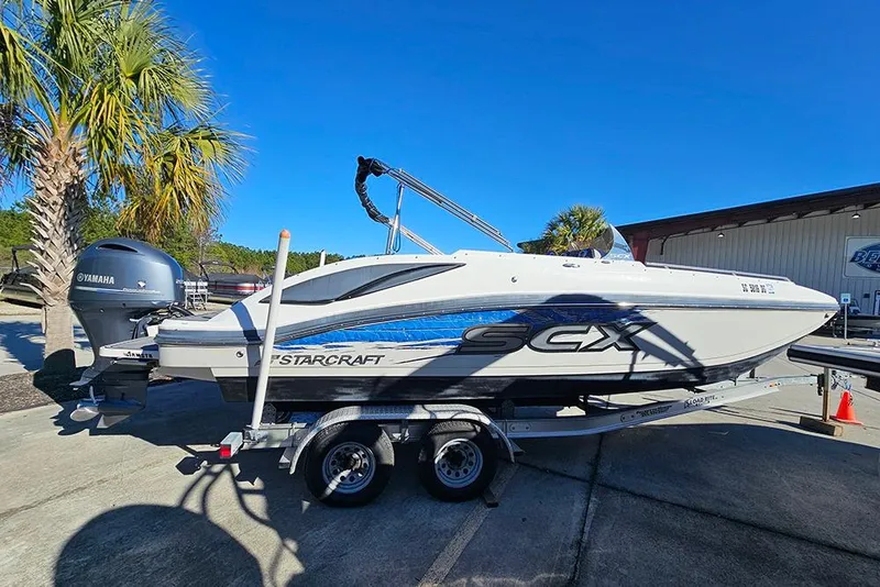 Slide: The Image of 2017 Starcraft Crossover 231 SCX OB boat on trailer, parked outdoors. - 7