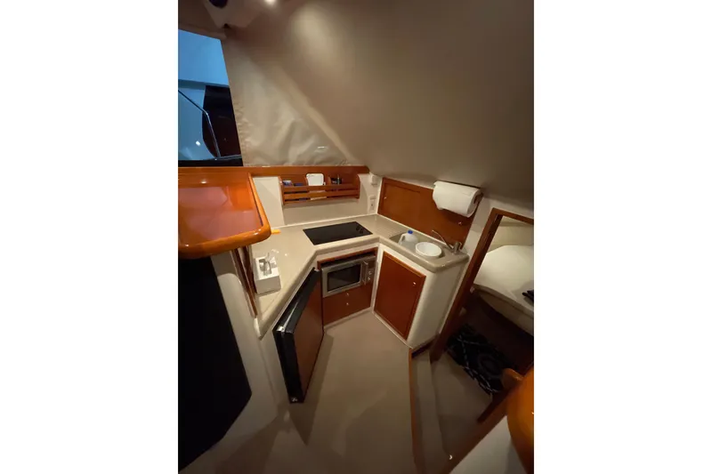 Slide: The Image of Interior of 2002 Riviera 34 Convertible yacht with cozy seating and nautical decor. - 10