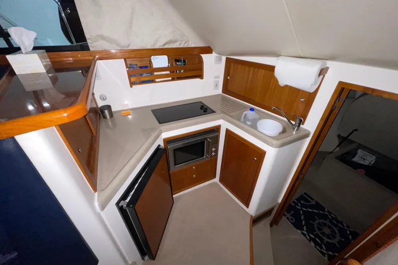 Slide: The Image of Luxurious interior of 2002 Riviera 34 Convertible yacht with elegant seating and wooden table. - 11