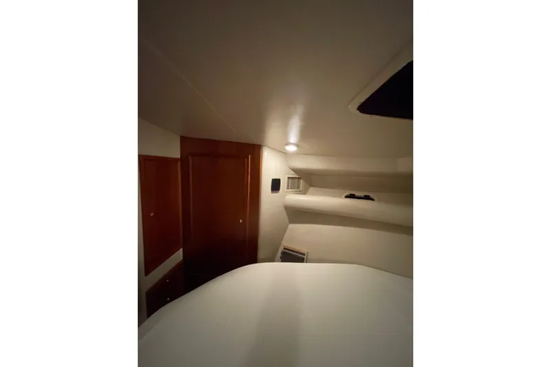 Slide: The Image of Cozy bedroom interior of 2002 Riviera 34 Convertible yacht with soft lighting. - 16