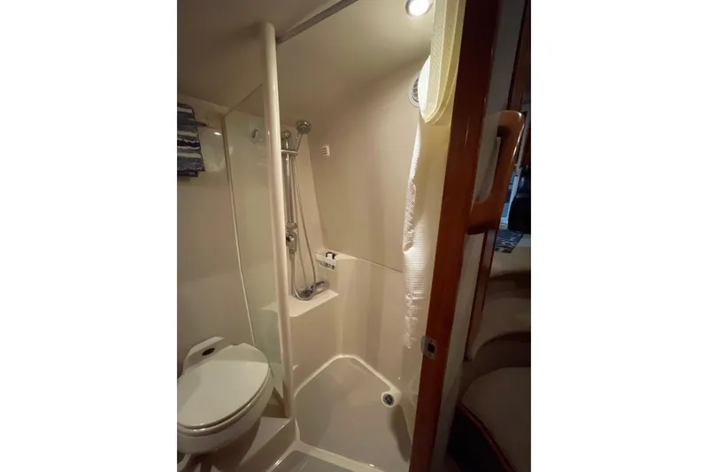 Slide: The Image of Interior cabin of 2002 Riviera 34 Convertible yacht with wooden door and cozy lighting. - 20