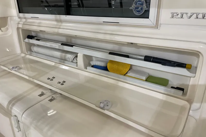 Slide: The Image of 2002 Riviera 34 Convertible boat interior with storage compartments and chrome handle. - 39