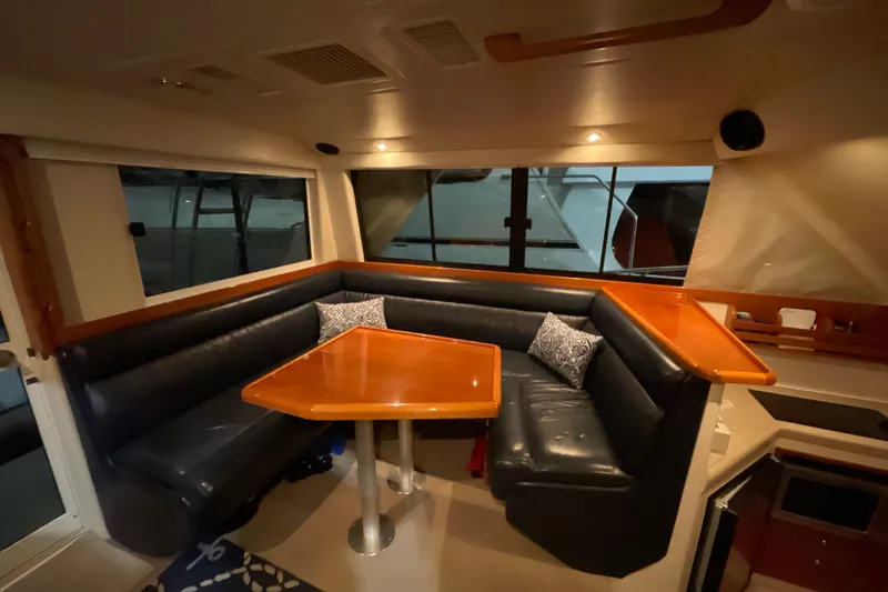 Slide: The Image of 2002 Riviera 34 Convertible yacht cruising on clear blue water under a sunny sky. - 5