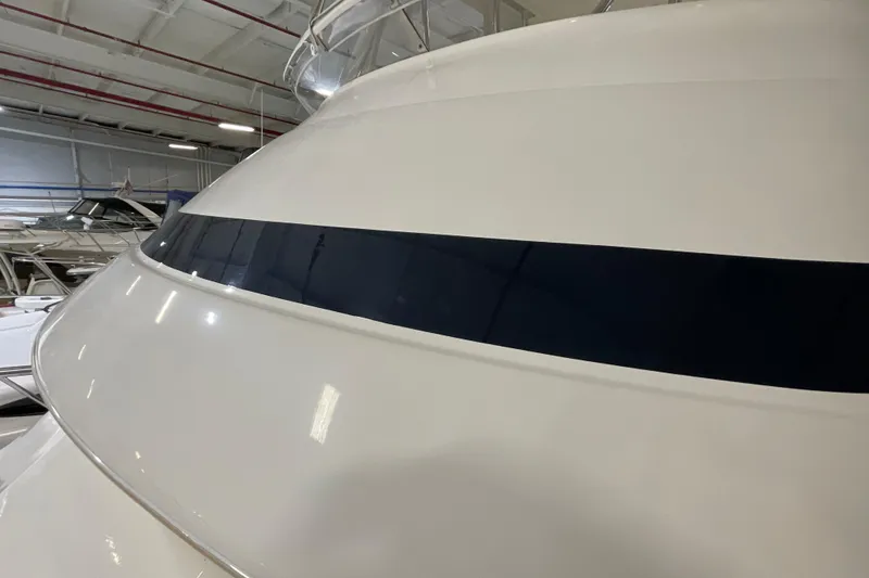 Slide: The Image of 2002 Riviera 34 Convertible yacht in indoor storage, showcasing sleek design and glossy finish. - 52