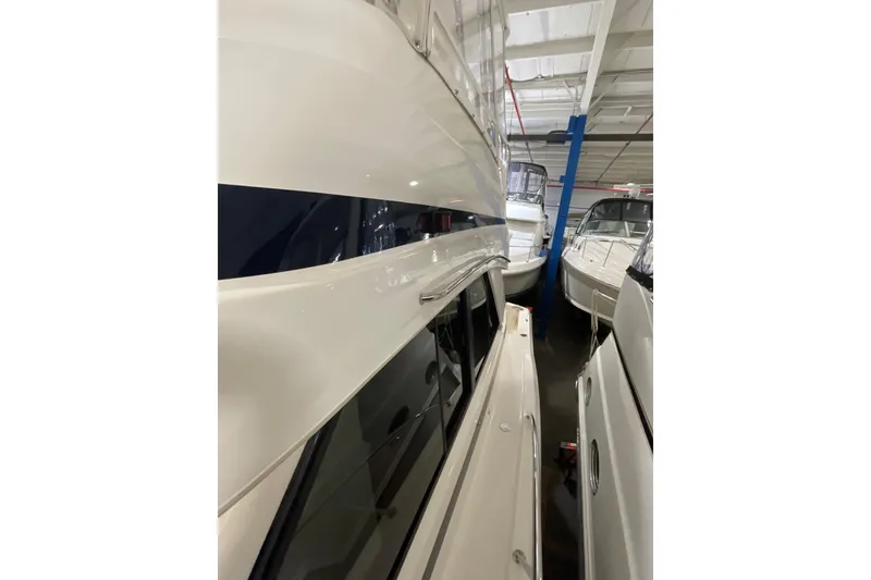 Slide: The Image of 2002 Riviera 34 Convertible yacht in indoor storage, side view. - 53