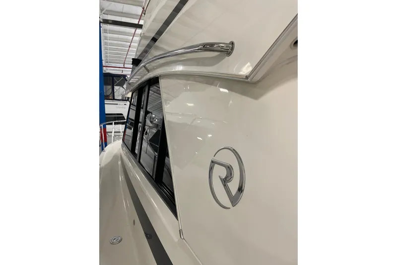 Slide: The Image of 2002 Riviera 34 Convertible yacht side view with logo and sleek design. - 54