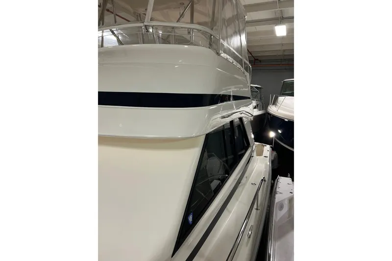 Slide: The Image of 2002 Riviera 34 Convertible yacht in indoor storage, showcasing sleek design and structure. - 58