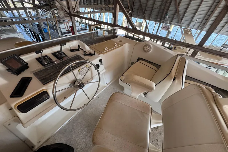 Slide: The Image of 1999 Gibson Houseboat 50 helm with steering wheel and control panel in marina. - 13