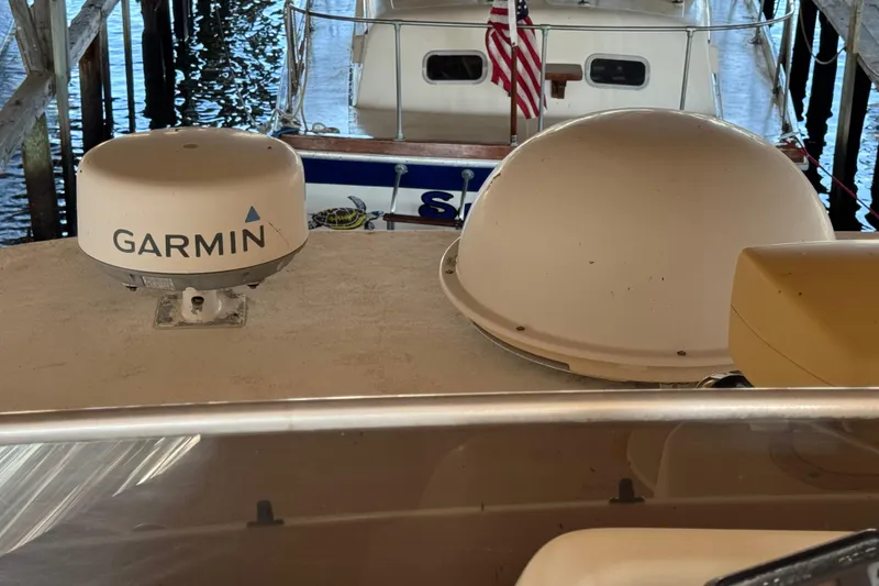 Slide: The Image of 1999 Gibson Houseboat 50 with Garmin equipment, docked under a covered marina. - 14