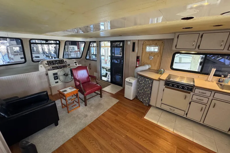 Slide: The Image of Interior of 1999 Gibson Houseboat 50 with helm, seating, and kitchen area. - 19