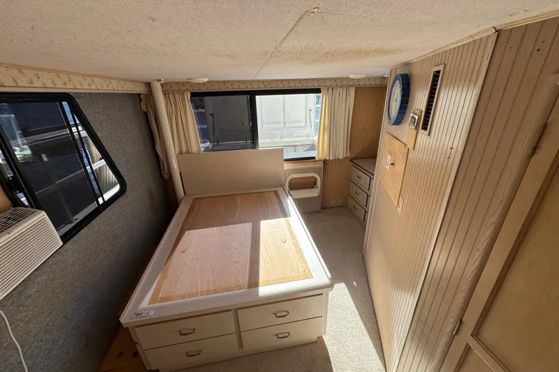 Slide: The Image of Interior of 1999 Gibson Houseboat 50, featuring a cozy bedroom with natural light. - 22