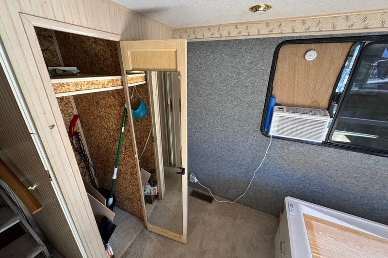Slide: The Image of Interior of 1999 Gibson Houseboat 50 with closet, mirror, and window air conditioner. - 24