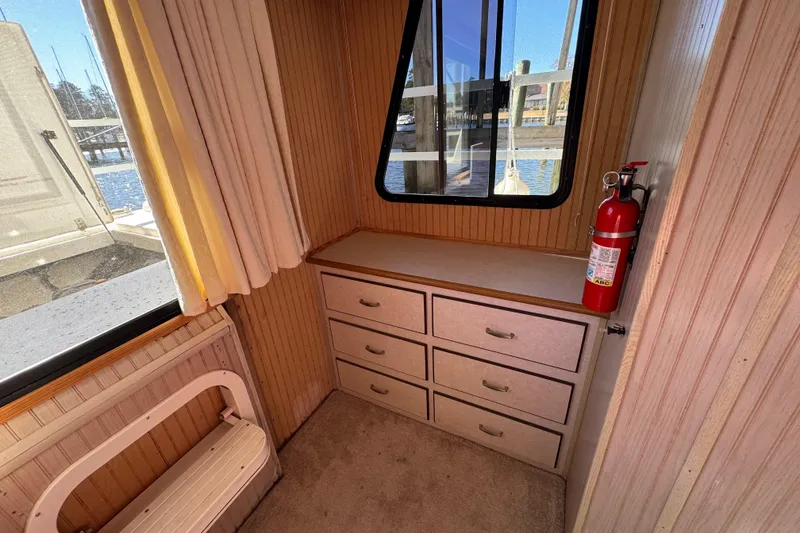 Slide: The Image of Interior of 1999 Gibson Houseboat 50 with drawers, window, and fire extinguisher. - 26
