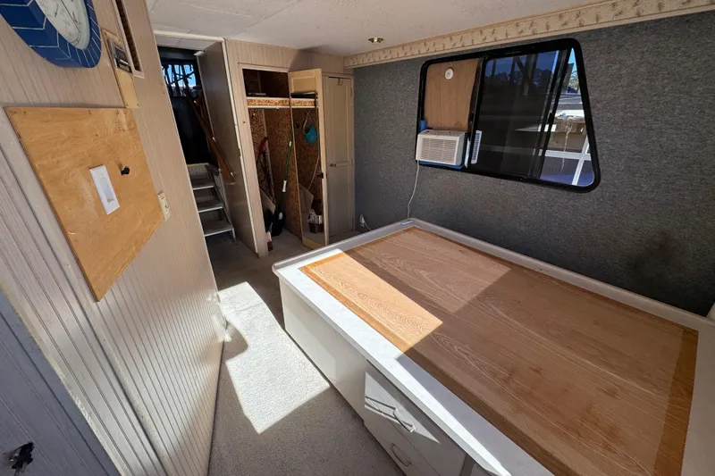 Slide: The Image of Interior of 1999 Gibson Houseboat 50 with bed, window, and storage space. - 29