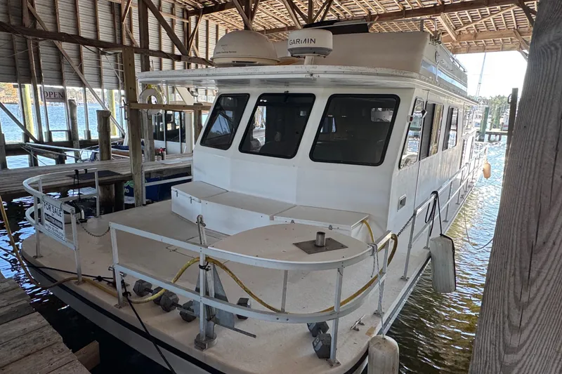 Slide: The Image of 1999 Gibson Houseboat 50 docked in a covered marina, available for sale. - 3