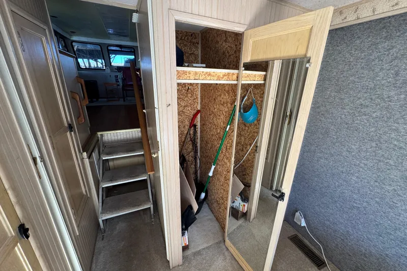 Slide: The Image of Interior of 1999 Gibson Houseboat 50 with stairs, closet, and cleaning tools. - 30