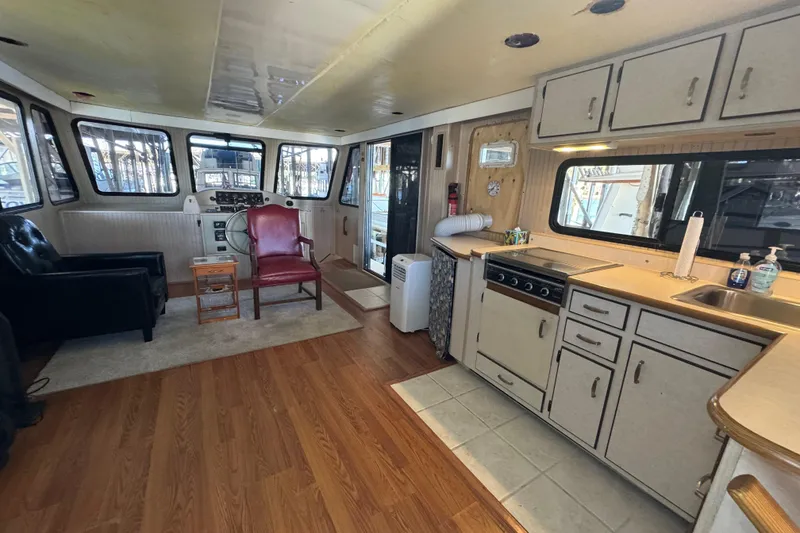 Slide: The Image of Interior of 1999 Gibson Houseboat 50 with kitchen and seating area. - 39