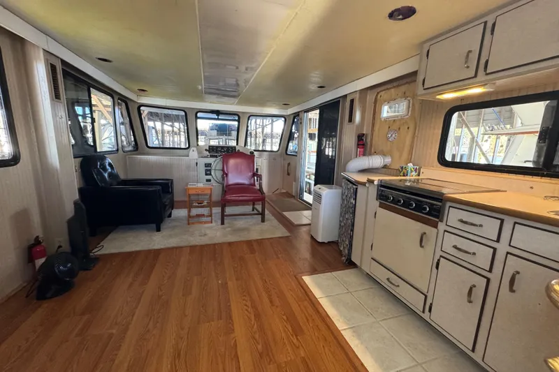 Slide: The Image of Interior of 1999 Gibson Houseboat 50 with kitchen and seating area, featuring wood flooring. - 41