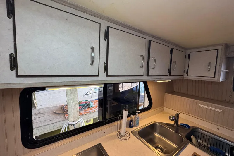 Slide: The Image of Interior kitchen view of a 1999 Gibson Houseboat 50, featuring cabinets and a sink. - 45