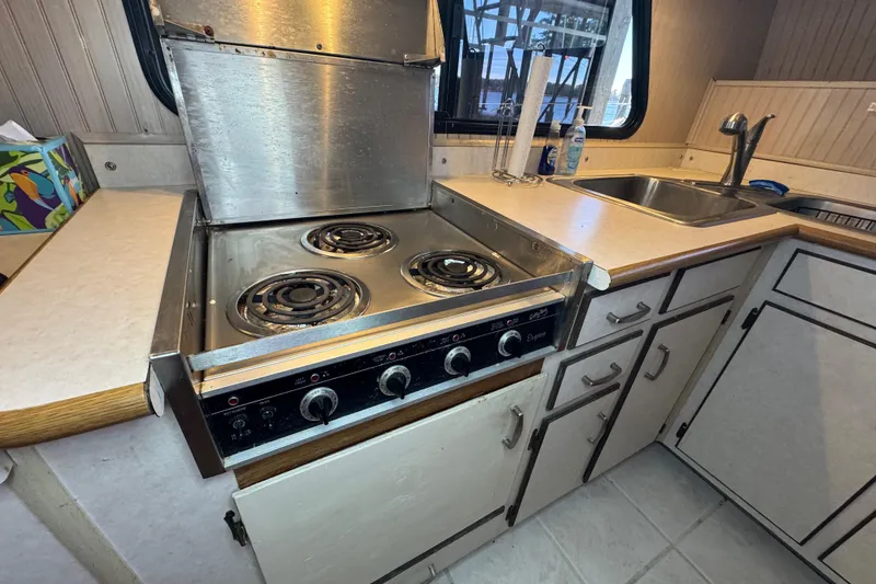 Slide: The Image of Kitchen area of a 1999 Gibson Houseboat 50 with stovetop and sink. No oven unit in this - 46