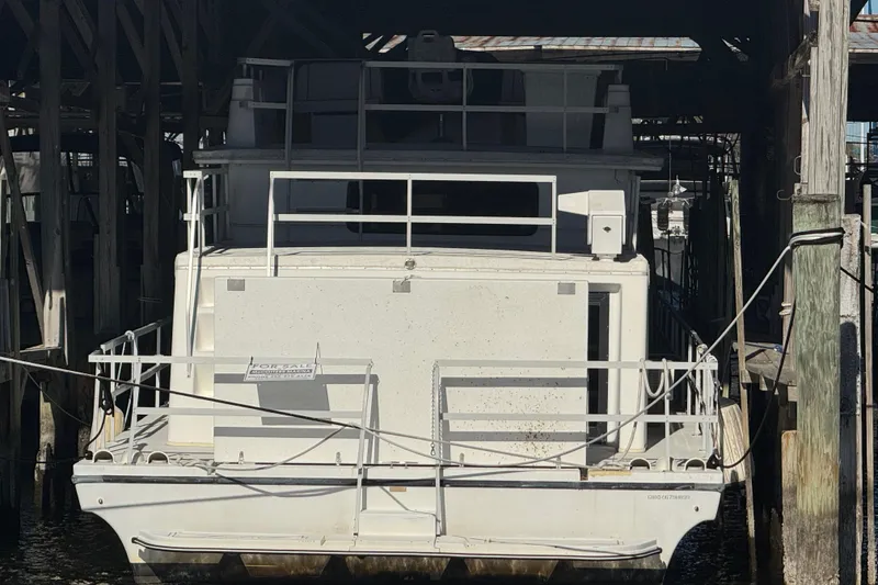 Slide: The Image of 1999 Gibson Houseboat 50 docked in a covered marina, front view. - 5