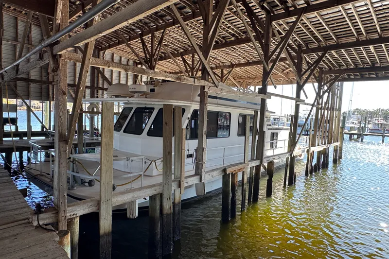 Slide: The Image of 1999 Gibson Houseboat 50 docked in a wooden marina shelter. - 6