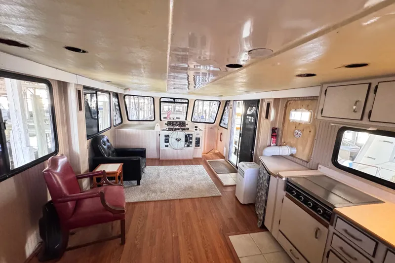 Slide: The Image of Interior of a 1999 Gibson Houseboat 50 with seating, helm, and kitchenette. - 65