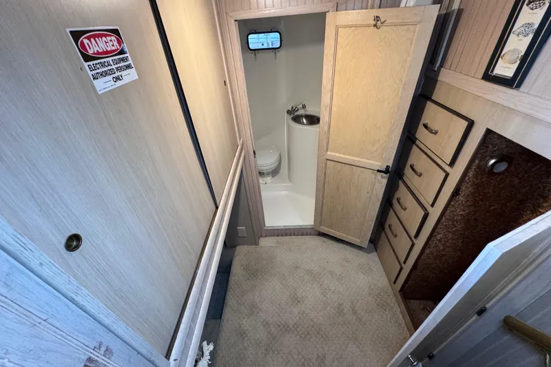 Slide: The Image of 1999 Gibson Houseboat 50 interior with compact bathroom and storage cabinets. - 67