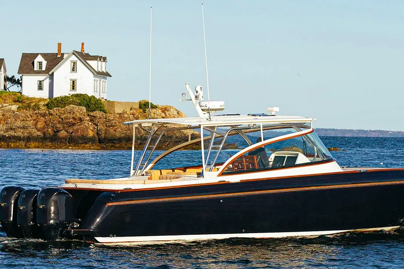 Slide: The Image of 2013 Intrepid 400 Cuddy boat cruising near coastal house. - 13