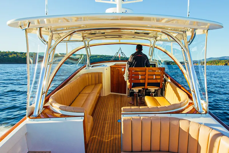 Slide: The Image of 2013 Intrepid 400 Cuddy boat interior with captain, featuring luxurious seating and scenic water view. - 14