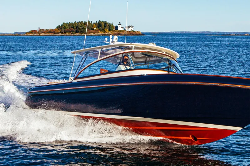 Slide: The Image of 2013 Intrepid 400 Cuddy cruising on open water near a scenic island. - 17