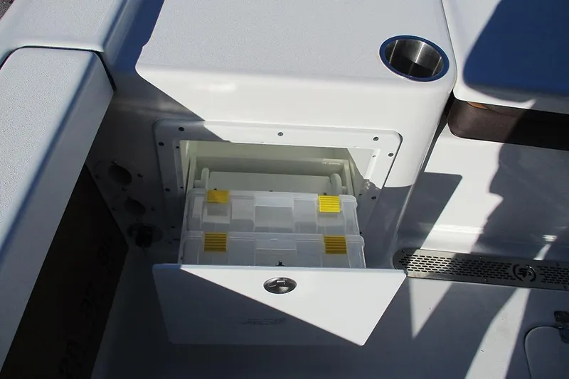 Slide: The Image of 2026 Sea Pro 250 Bay boat storage compartment with tackle boxes and cup holder. - 38