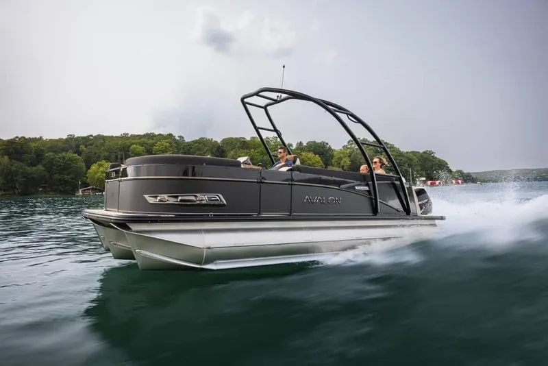The Image of 2026 Avalon 2385 LSZ Q pontoon boat cruising on a scenic lake. - 1