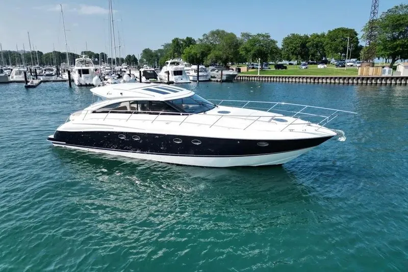 The Image of 2008 Princess V53 yacht cruising in a marina with clear blue water. - 1