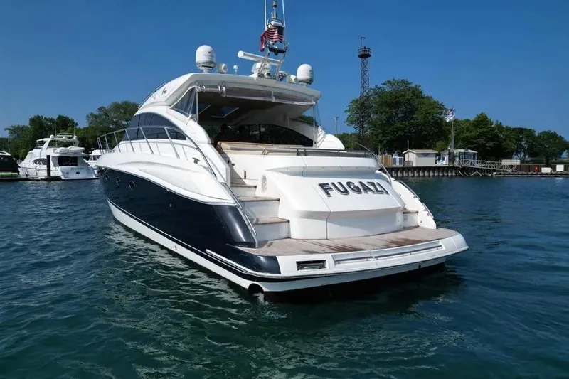 Slide: The Image of 2008 Princess V53 yacht named "Fugazi" docked in a marina under clear blue skies. - 16