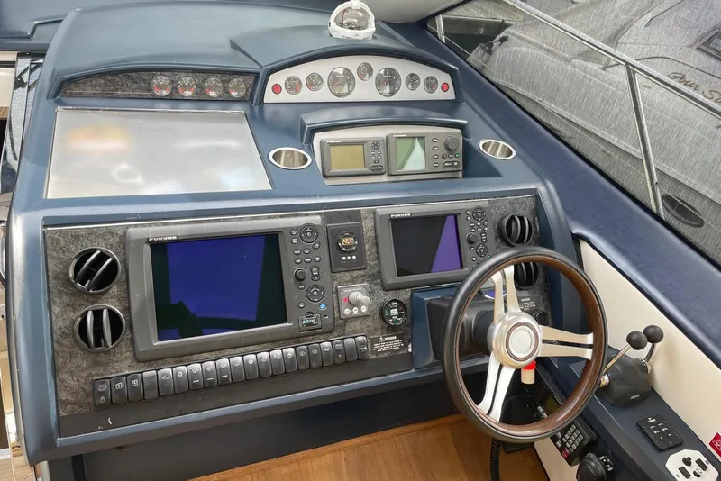 Slide: The Image of Control panel of a 2008 Princess V53 yacht with navigation instruments and steering wheel. - 38